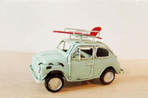 Sky blue miniature car with red surfboard